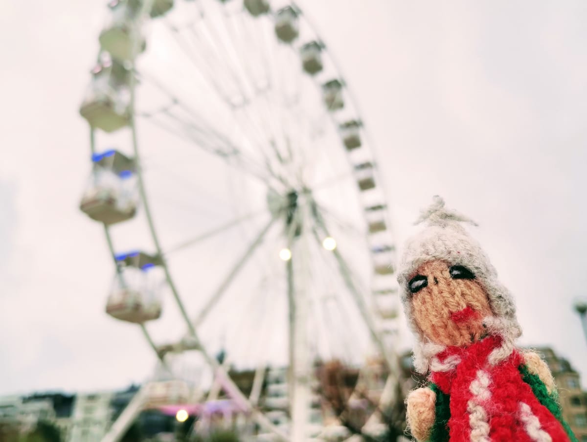 A moist Peruvian finger puppet struggled to contain its excitement in front of a blurred Ferris wheel.
